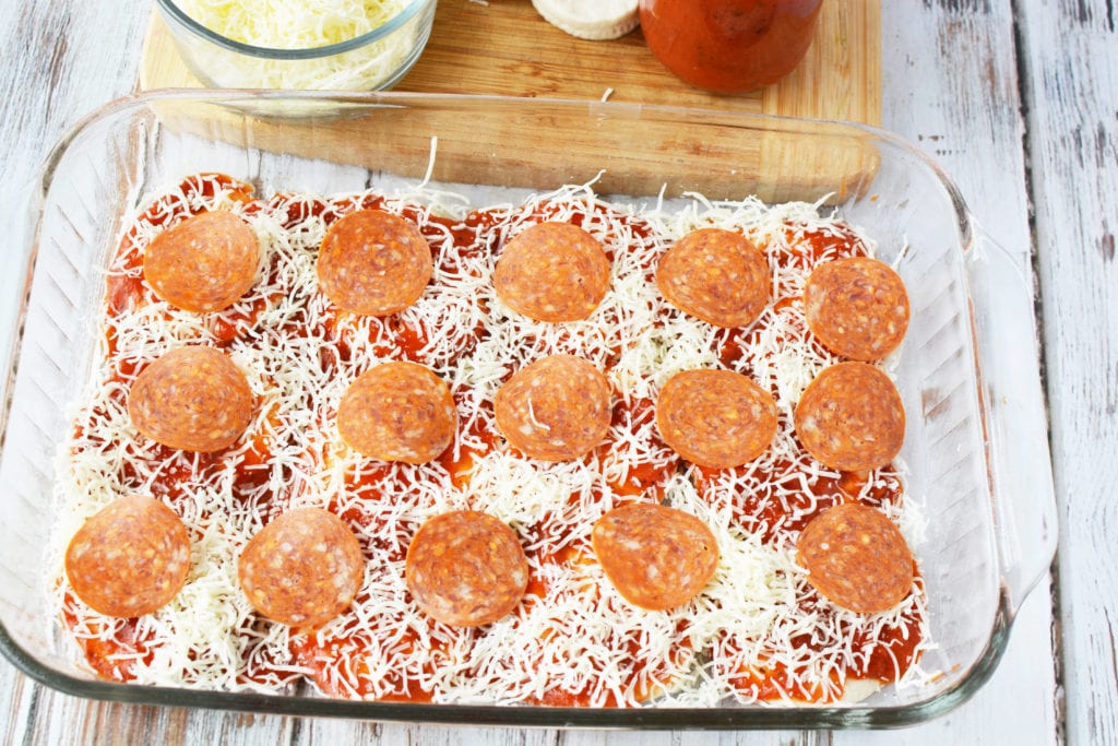 pizza bake layer one with biscuits, sauce, cheese, and pepperoni