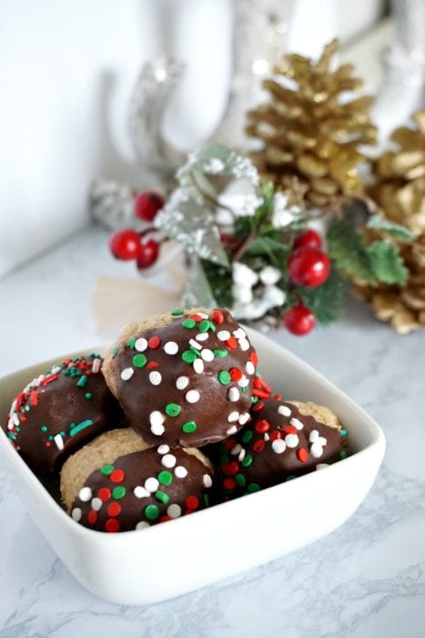 These peanut butter balls are the perfect no bake Christmas treat to give out to neighbors. They are a fast Christmas dessert idea that look festive, and combine the favorite flavors of peanut butter and chocolate. The best part, is that it is a Christmas treat idea that comes together in 30 minutes. #christmastreat #christmasdessert #neighborgifts #giftideas #peanutbutterballs #chocolateandpeanutbutterThese peanut butter balls are the perfect no bake Christmas treat to give out to neighbors. They are a fast Christmas dessert idea that look festive, and combine the favorite flavors of peanut butter and chocolate. The best part, is that it is a Christmas treat idea that comes together in 30 minutes. #christmastreat #christmasdessert #neighborgifts #giftideas #peanutbutterballs #chocolateandpeanutbutter