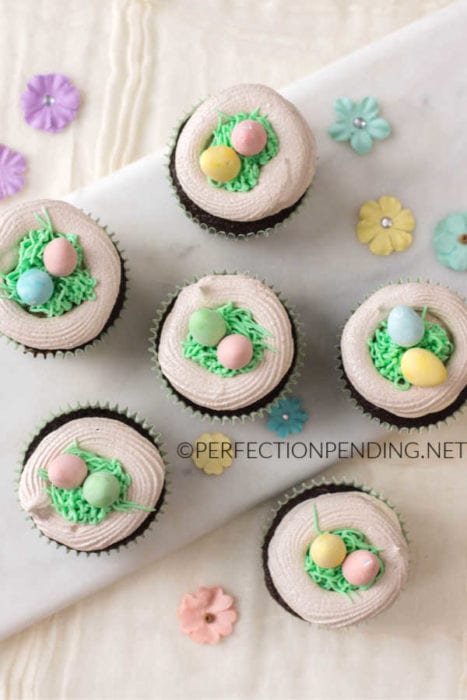 These chocolate cupcakes with a meringue bird's nest are perfect for your Easter party or Spring fun. With buttercream grass and bright colorful easter eggs, these fun Meringue Robin's egg nests make the perfect addition to your Easter chocolate cupcake. #Eastercupcakes #birdnestcupcakes #springcupcakes #Easterdessertidea