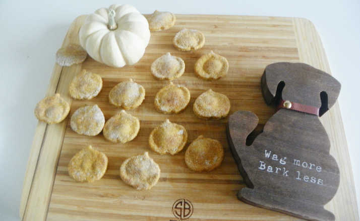 pumpkin dog treats on cutting board with wag more bark less wooden dog