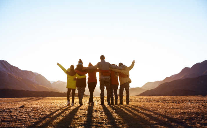 back of Group of friends in the mountains with arms around each other. How to make friends in your 30's